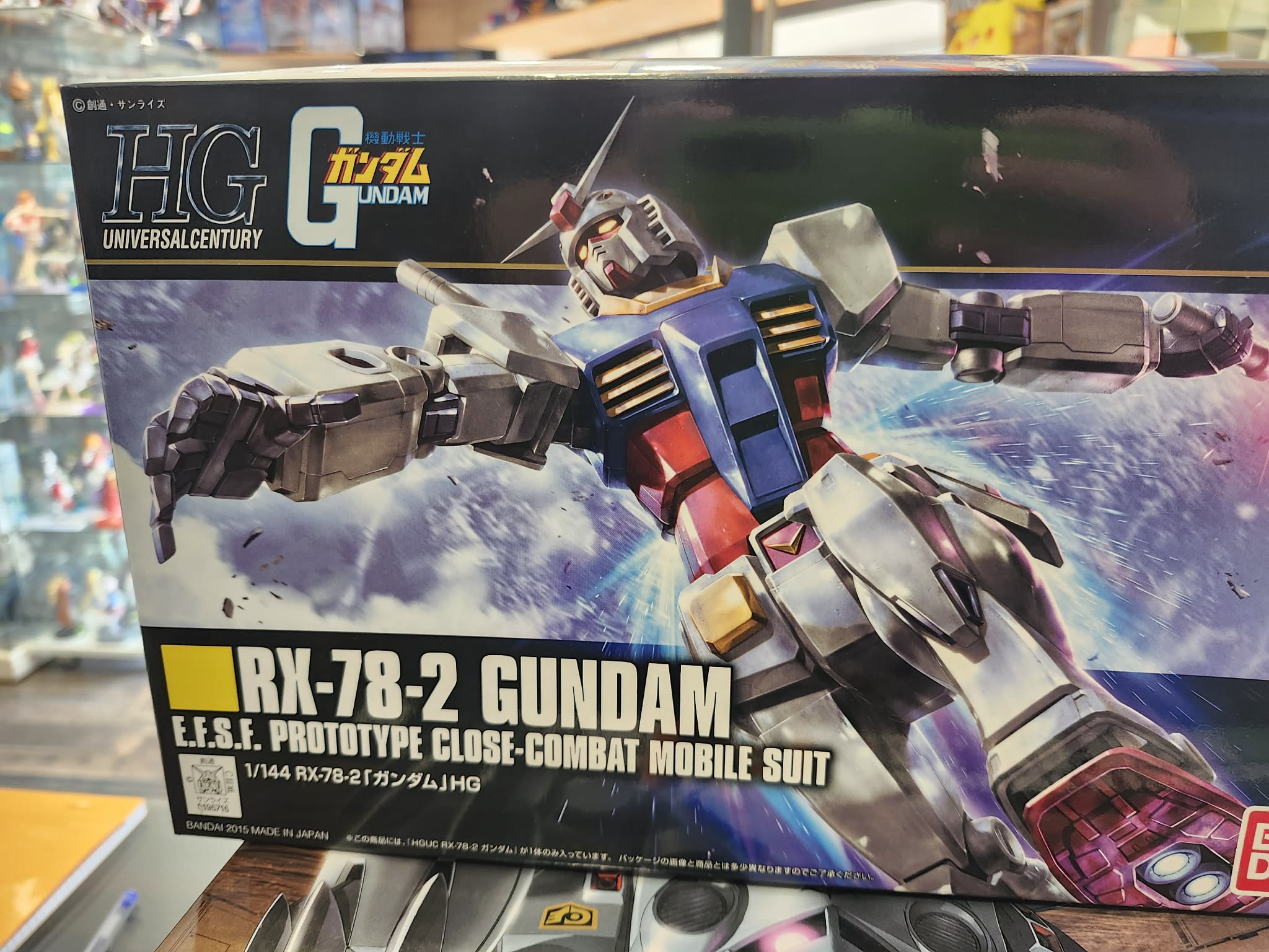 Photographie de la boîte de maquette Bandai Namco High Grade (HG) représentant le mobile suit iconique RX-78-2 Gundam en position de combat dynamique, issue de la gamme Universal Century.