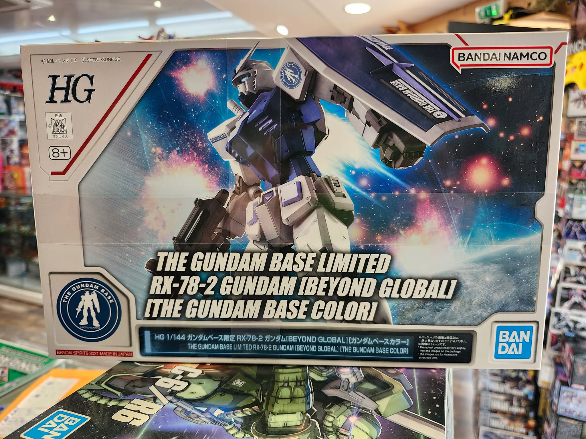 Photographie de la boîte de maquette Bandai Namco High Grade (HG) représentant le modèle exclusif RX-78-2 Gundam [Beyond Global] aux couleurs de The Gundam Base, en position dynamique avec son bouclier.