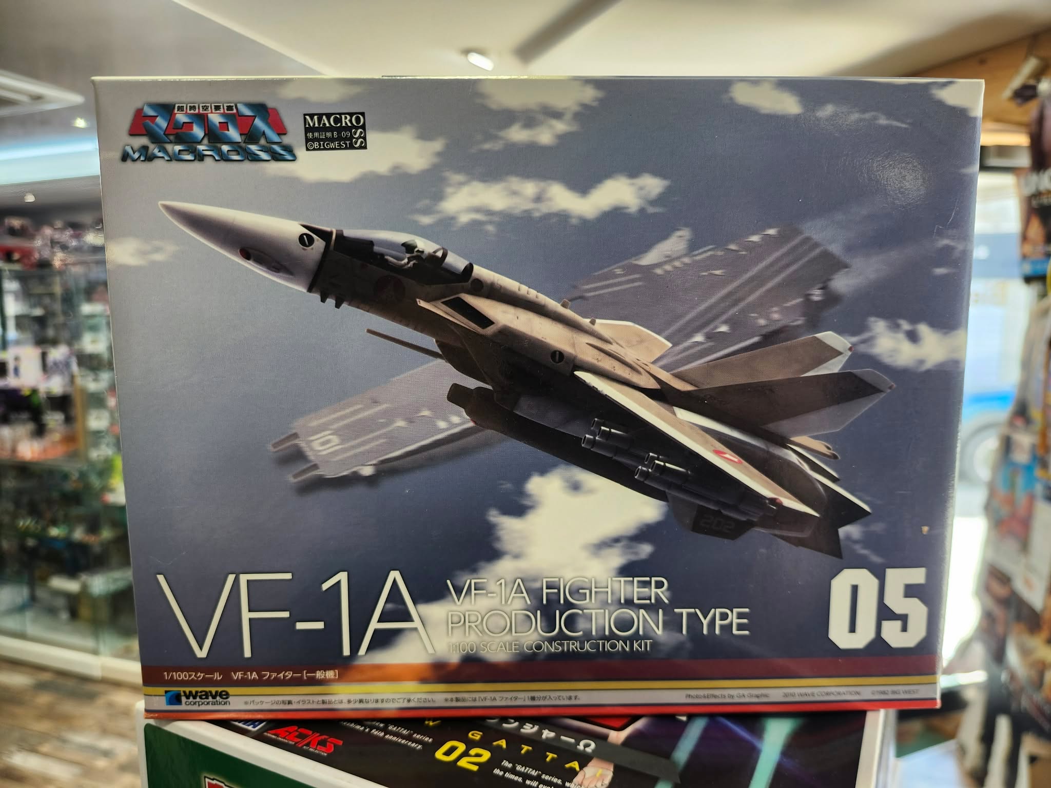 Photographie de la boîte de maquette WAVE représentant le MG Macross VF-1A Fighter No.05, un modèle de chasseur mecha inspiré de l'univers Macross.