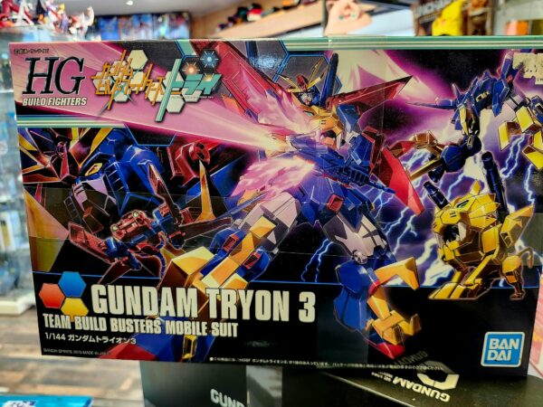 Photographie de la boîte de maquette Bandai représentant le HG Gundam Tryon 3, un Gunpla spectaculaire inspiré de Gundam Build Fighters Try.